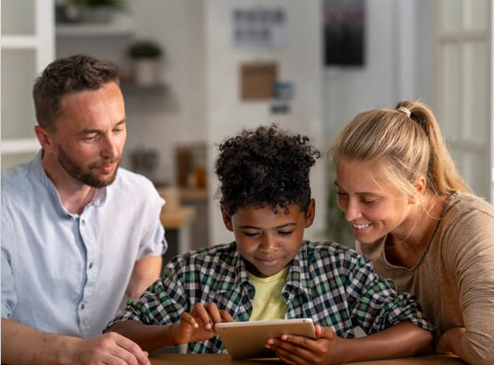 A close-knit family sharing a tablet, engrossed in the screen and bonding over digital content.